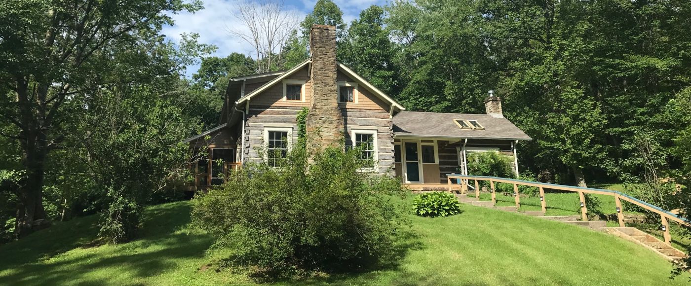 A Large Green Tree In Front Of A House
