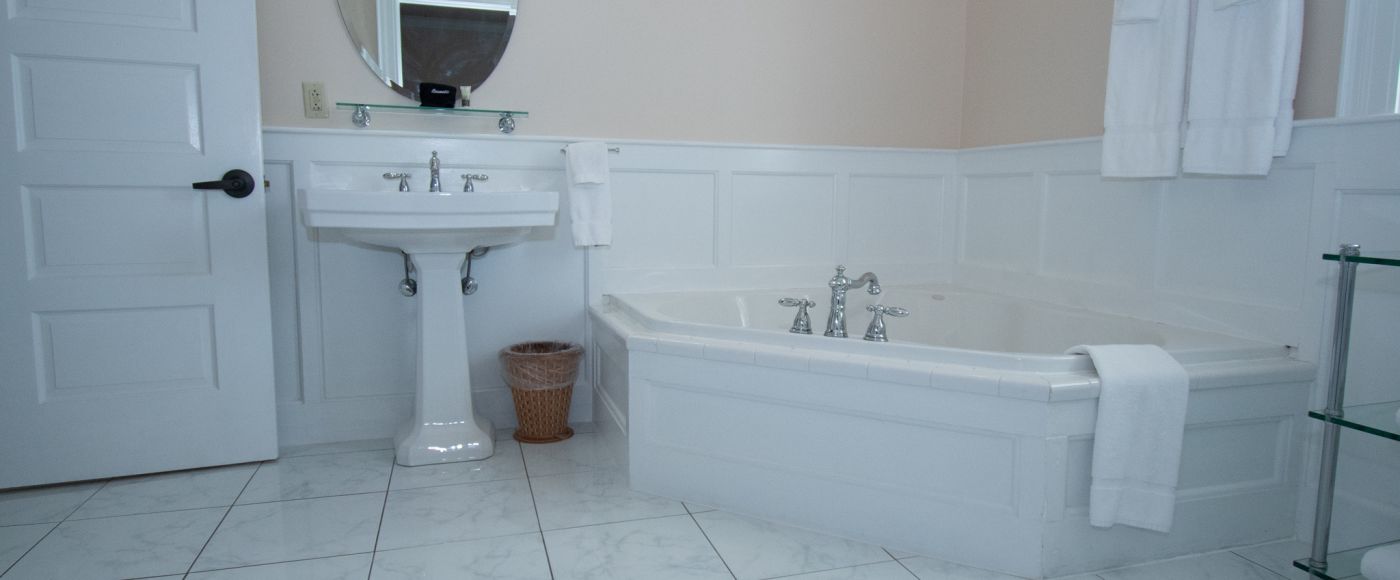 A Large White Tub Next To A Sink